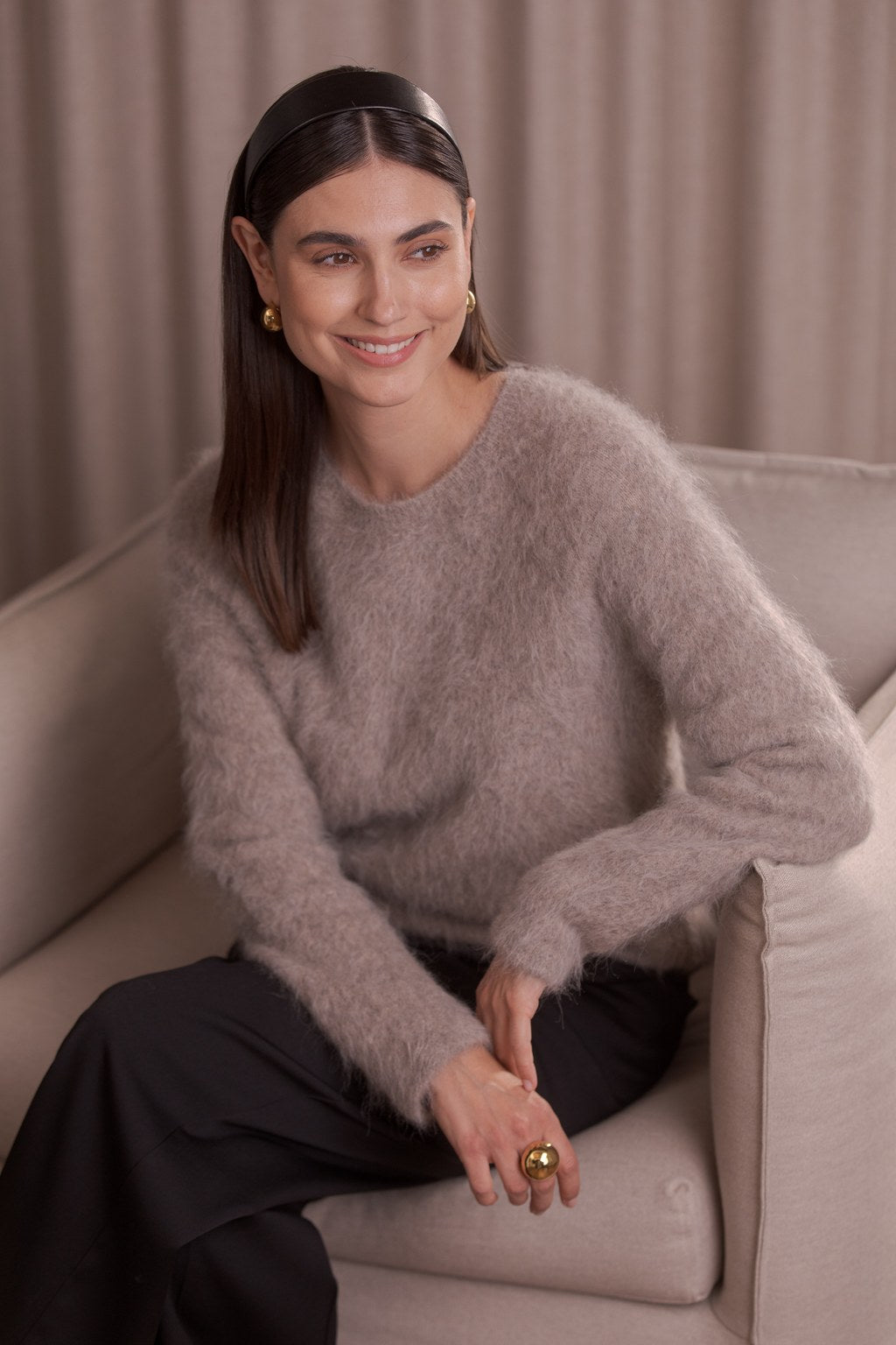 Nainen, jonka päällä Original Storyn pitkähihainen alpakkasekoiteneule sävyssä greige