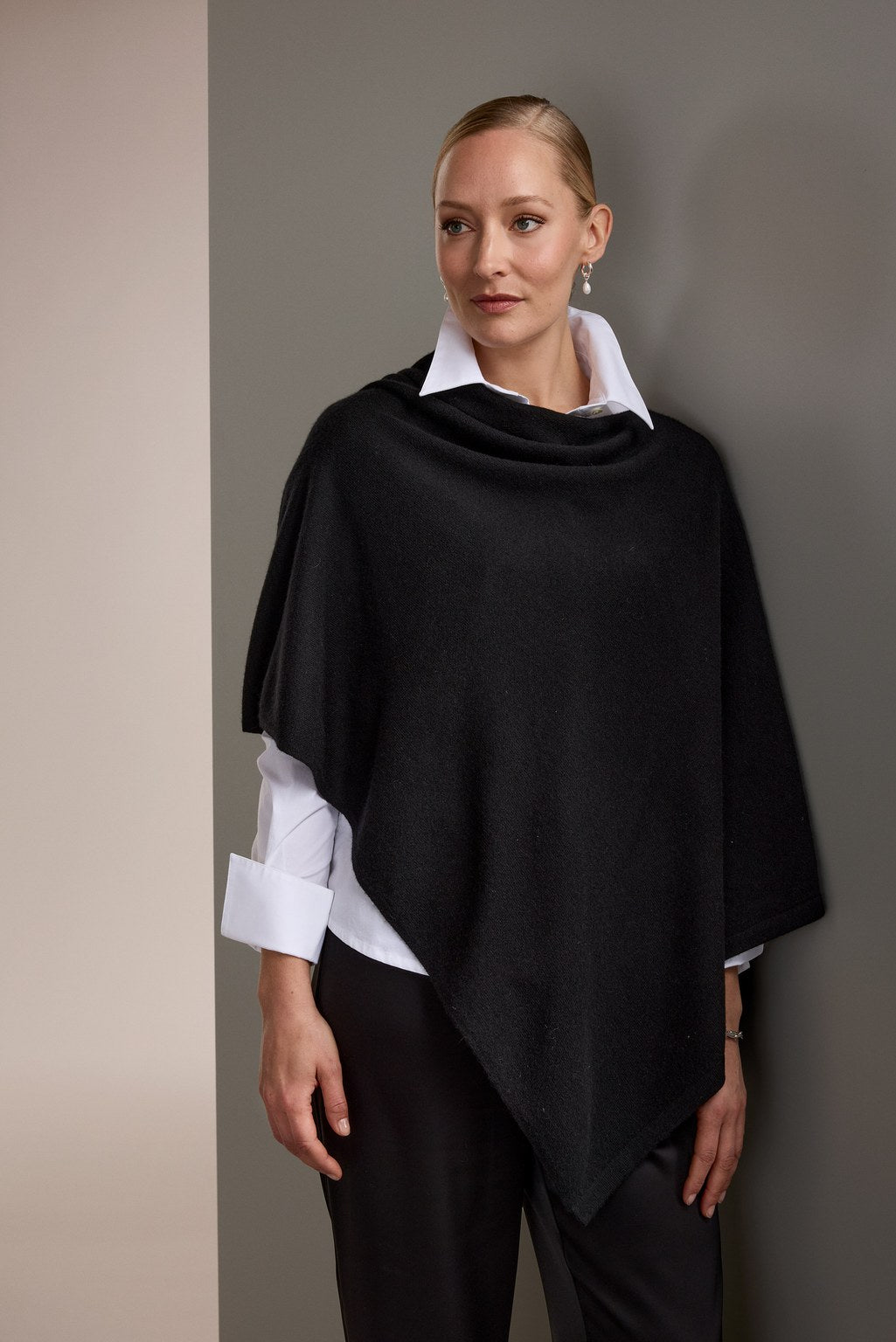 Nainen, jonka päällä on Original Storyn kashmirponcho, musta.