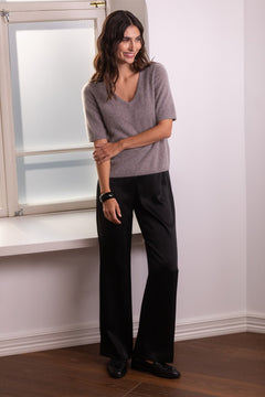 Original Storyn nougat-sävyinen lyhythihainen kashmirneule v-kaula-aukolla sekä mustat leveälahkeiset satiinihousut