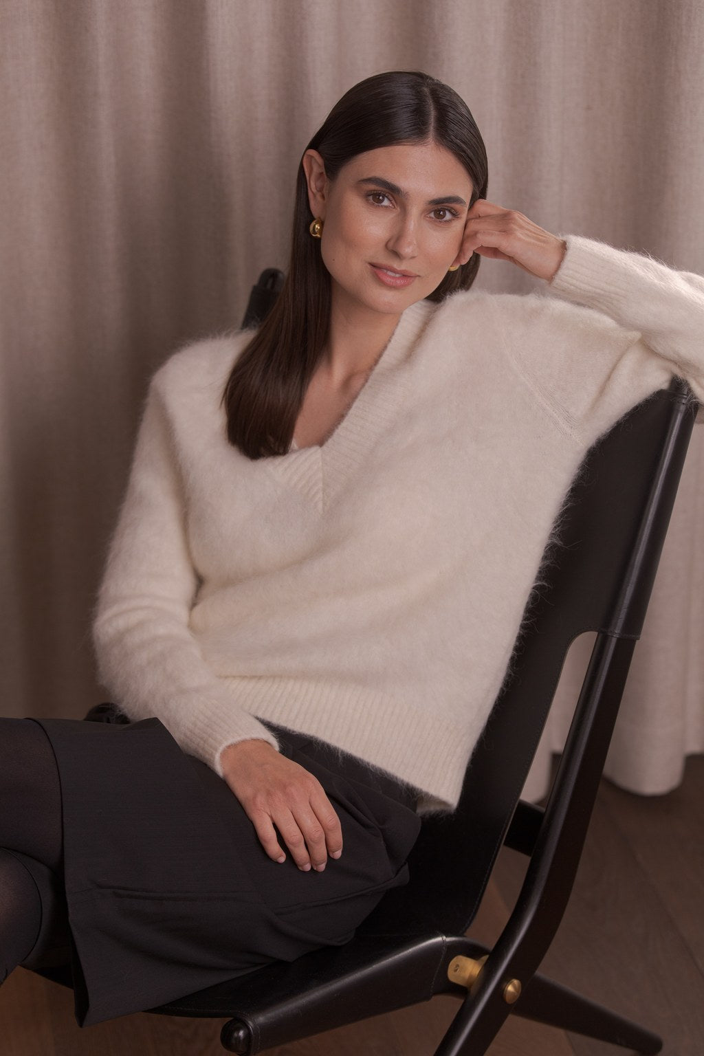 nainen, jonka päällä kermanvalkoinen alpakkasekoiteneule v-kaula-aukolla