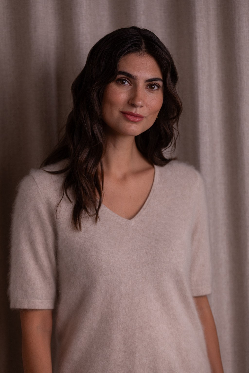 Lähikuva lyhythihaisesta v-kaula-aukollisesta kashmirneuleesta, sävy latte