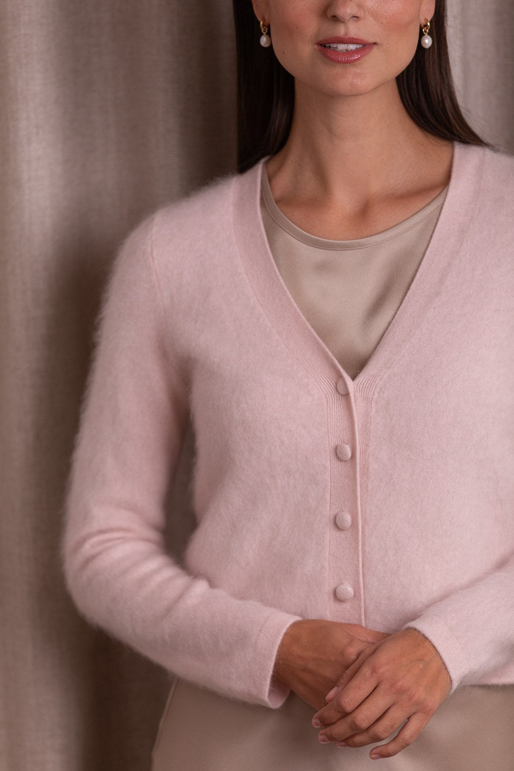 Lähikuva kashmirista valmistetusta pitkähihaisesta neuletakista, jossa v-kaula-aukko, sävy pale pink